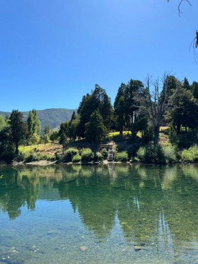 Alma Andina a orillas del río, frente al lago